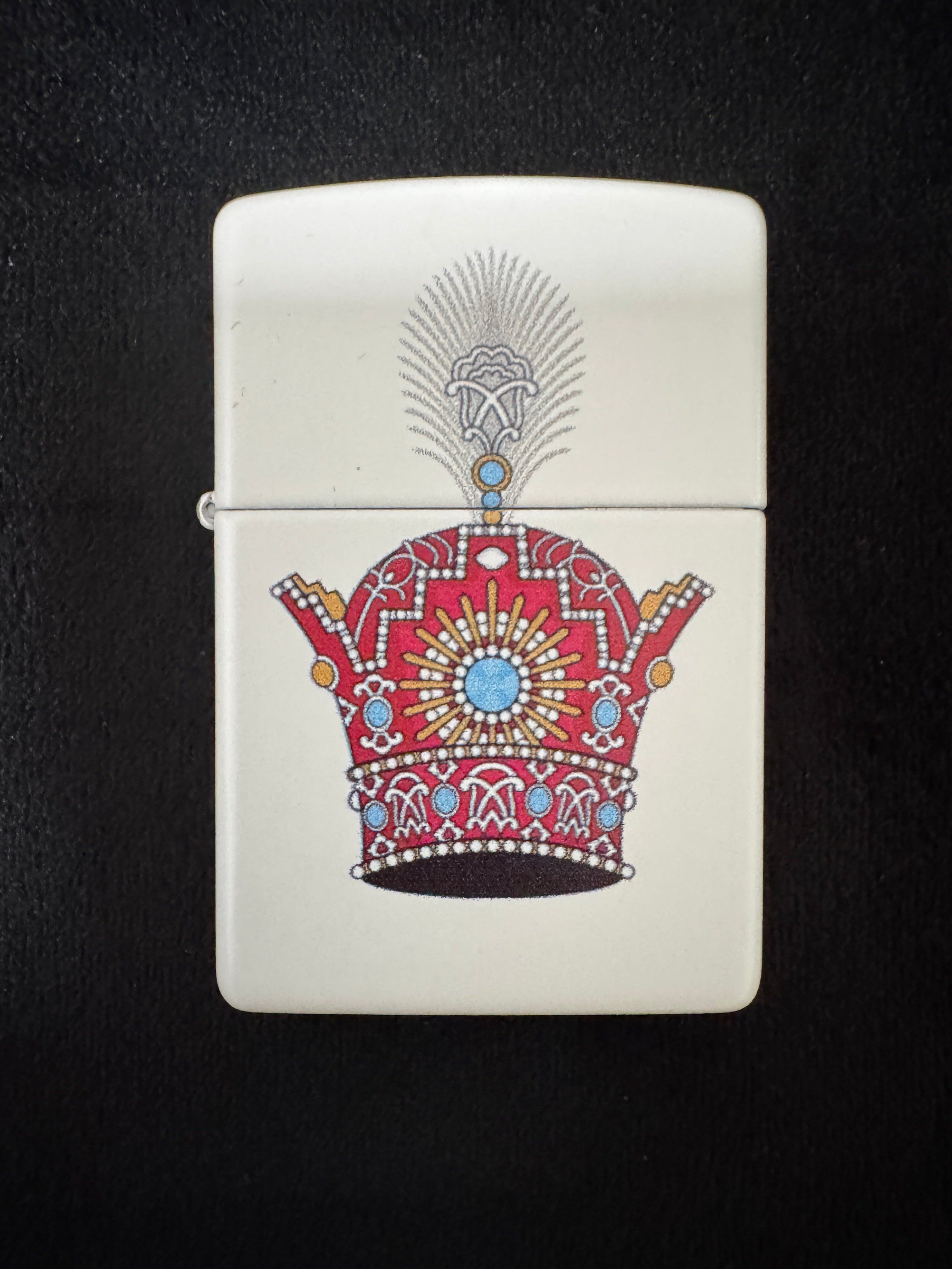 White lighter with red jeweled Pahlavi Crown design on black background